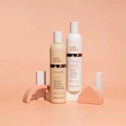 Two bottles of Milk Shake Integrity shampoo and conditioner on a peach background