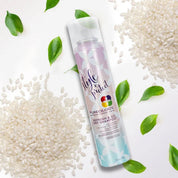 Pureology dry shampoo bottle surrounded by rice grains and leaves on a white background