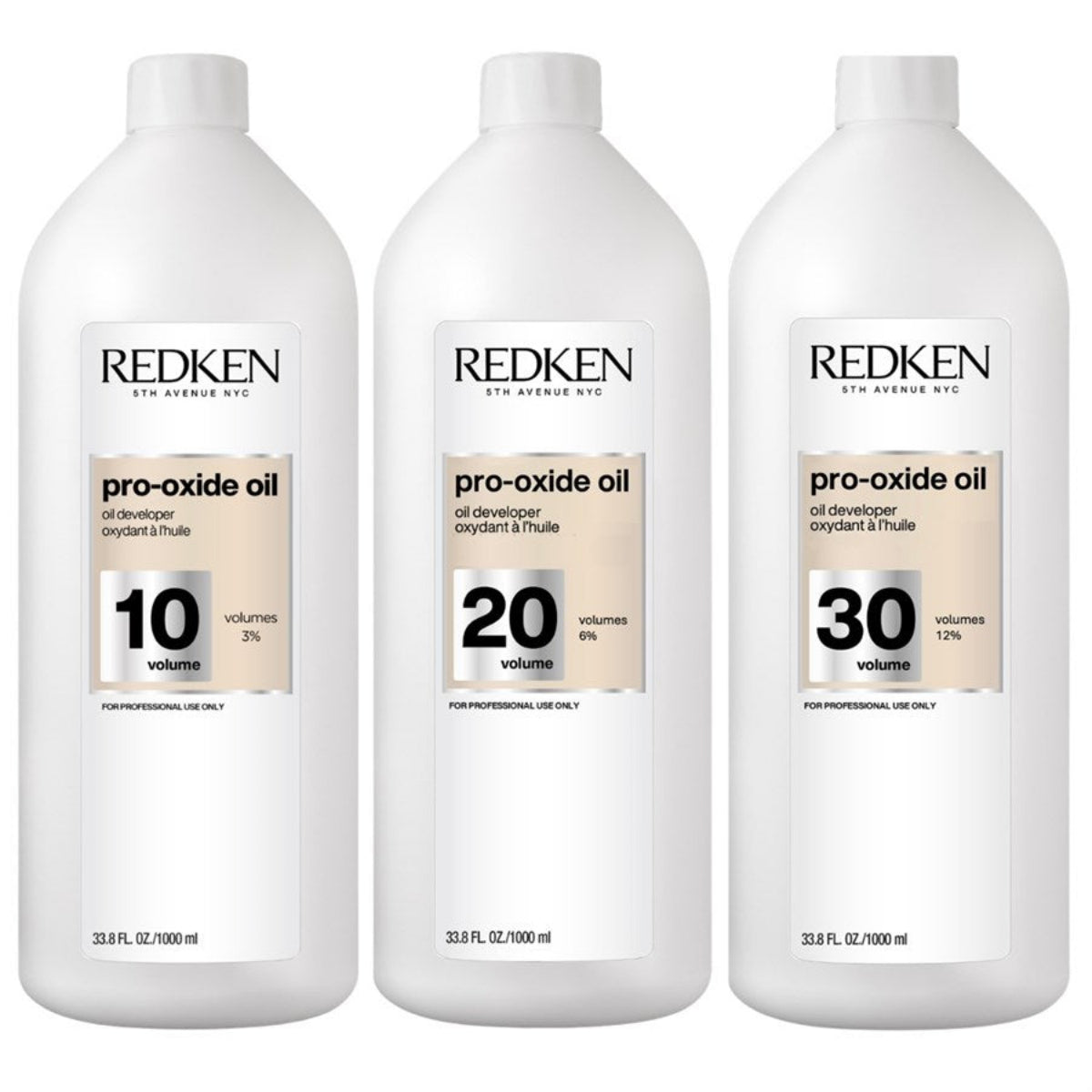 Three large white bottles of Redken Pro-Oxide Oil in 10, 20, and 30 volumes, arranged side by side on a white background.