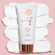 Tube of 'it's a 10 Coily' miracle moisture cream on a white towel with a pink background