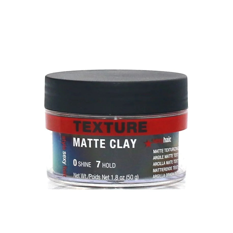 A small jar of Texture Matte Clay in the shade Pink, featuring a black lid and a label with red, black, and white text, set against a plain white background.