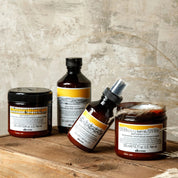 Set of Davines hair care products on a wooden surface with a textured wall background