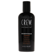 A black bottle of American Crew Fortifying Shampoo for Men, 3.3 oz in size, with white and orange text labeling.