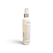 A white bottle of UNITE Booster Spray with a silver pump collar and a translucent cap, shown from the back on a white background.
