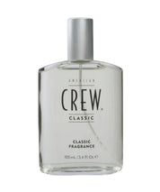 Clear bottle of American Crew Classic fragrance on a white background