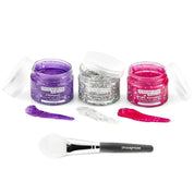 Three jars of skincare product with applicators and a brush on a white background