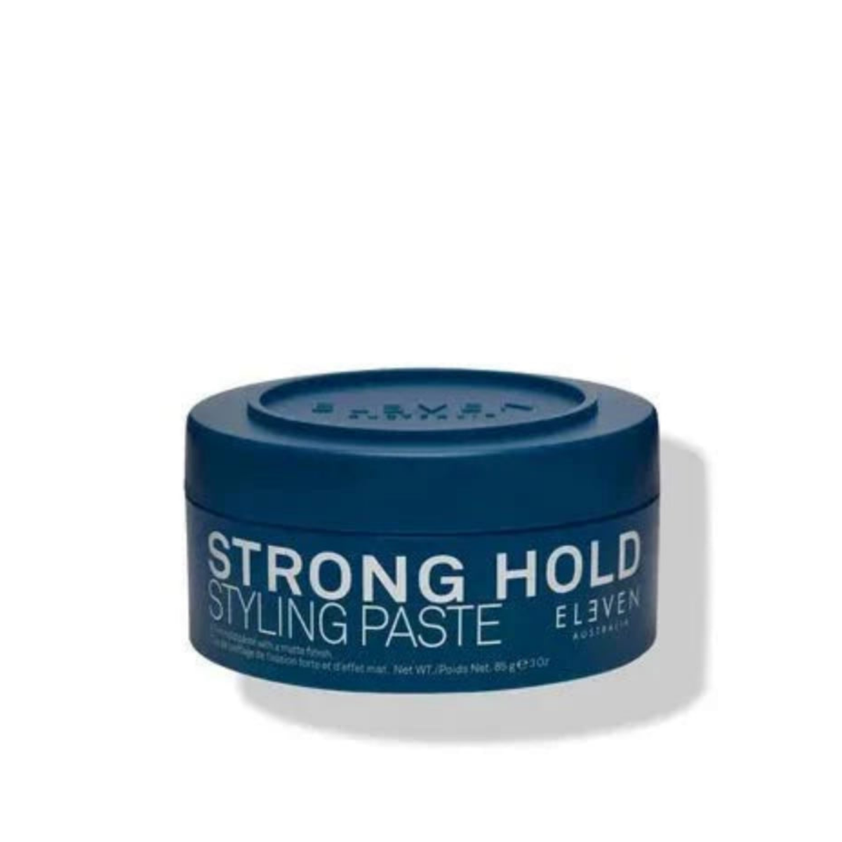 A dark blue jar of Eleven Strong Hold Styling Paste on a white background with a soft shadow.