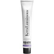 A white tube of KeraLuminous Keratin Complex permanent hair color with a black cap and a purple accent band, shown against a plain white background.