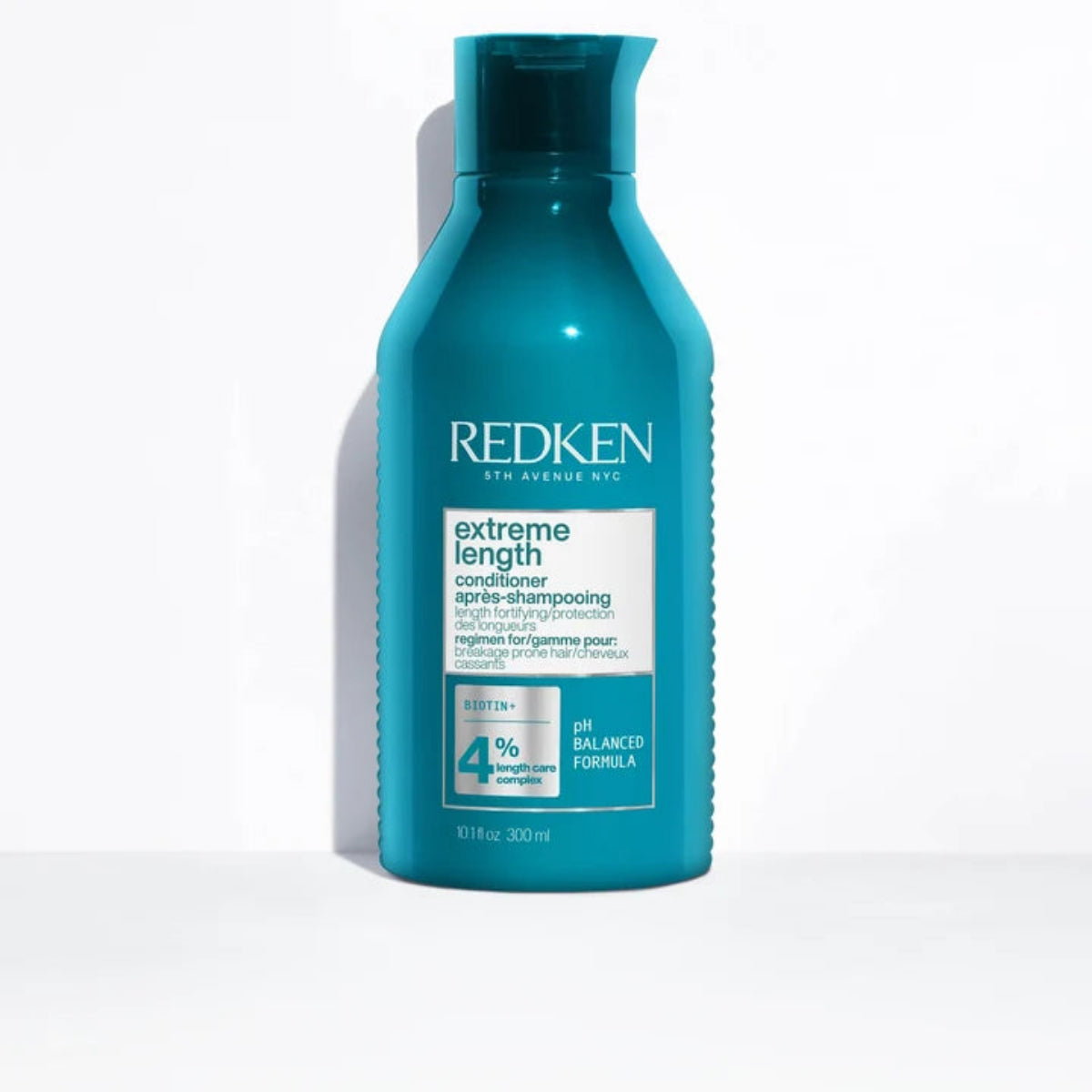 A 300 ml bottle of Redken Extreme Length Conditioner in a vibrant teal blue color, standing upright on a white surface with a soft shadow to the left.