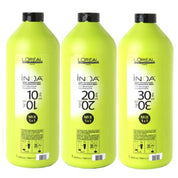Three bottles of L'Oreal INOA hair care product on a white background