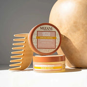 Mizani Artful Edges hair product with a wooden comb and pumpkin on a neutral background